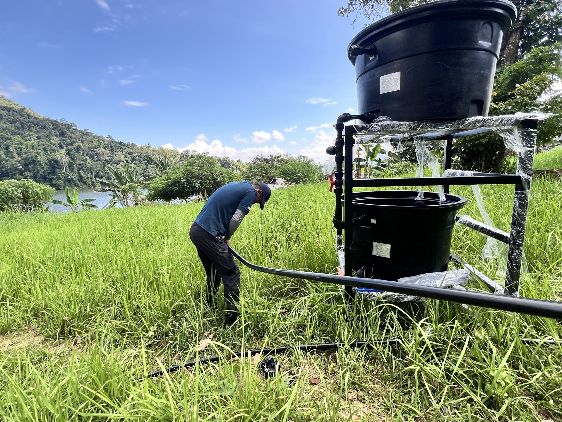 Orang Asli children filling bottles from a newly installed clean water tap in their village