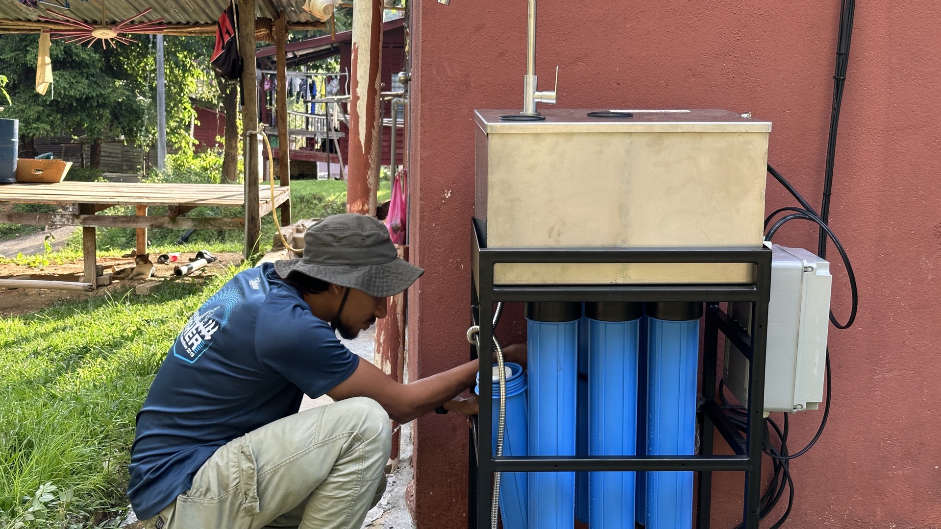 Saora+ WaSH programme in action — water filtration unit and pipework delivering clean water at Kampung Sungai Raba